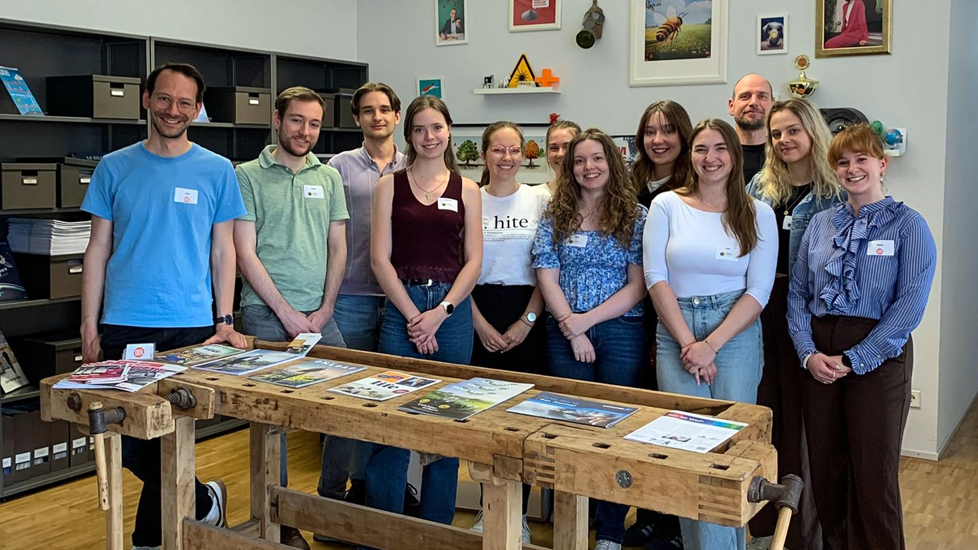 Eine Gruppe gut gelaunter Student*innen hat sich beim Besuch in der Agentur "Die Magaziniker" zum Gruppenbild aufgestellt.